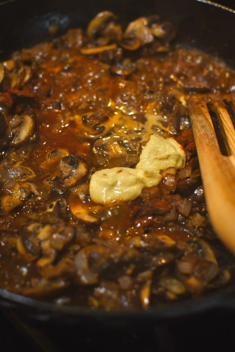 Deglazing the pan with the white wine and stirring in the dijon.