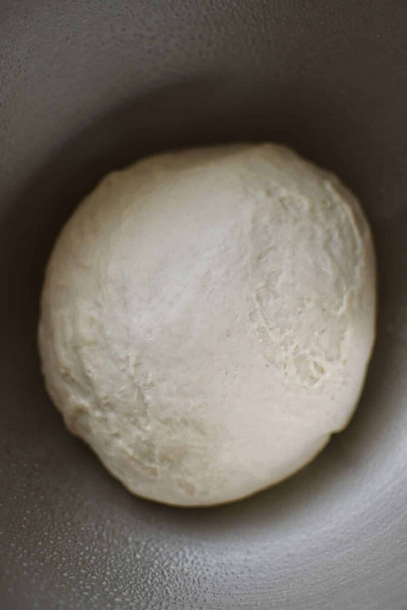 A smooth dough that has formed in the stand mixer for pretzel dough.