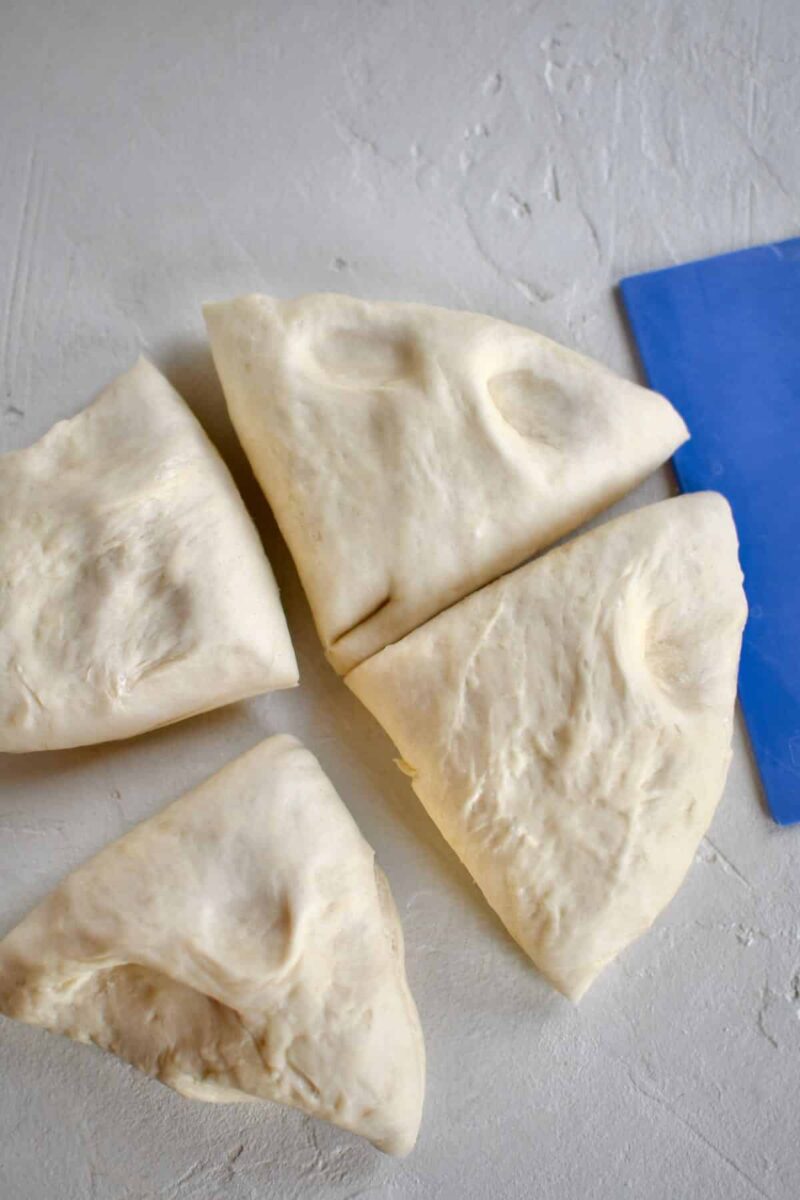 cutting the proved dough into 4 pieces before rolling out and cutting.