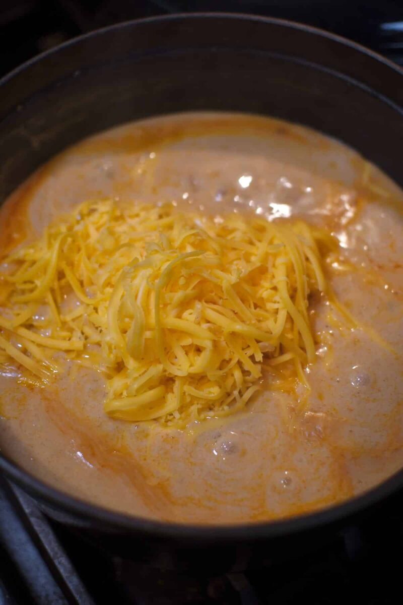 Adding the cheese to the soup before blending to make it smooth.