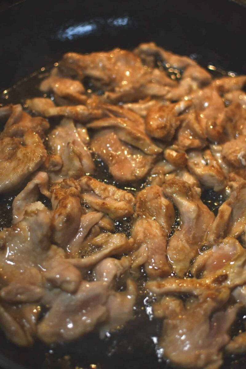 Cooking the quickly marinated chicken in the toasted sesame oil.
