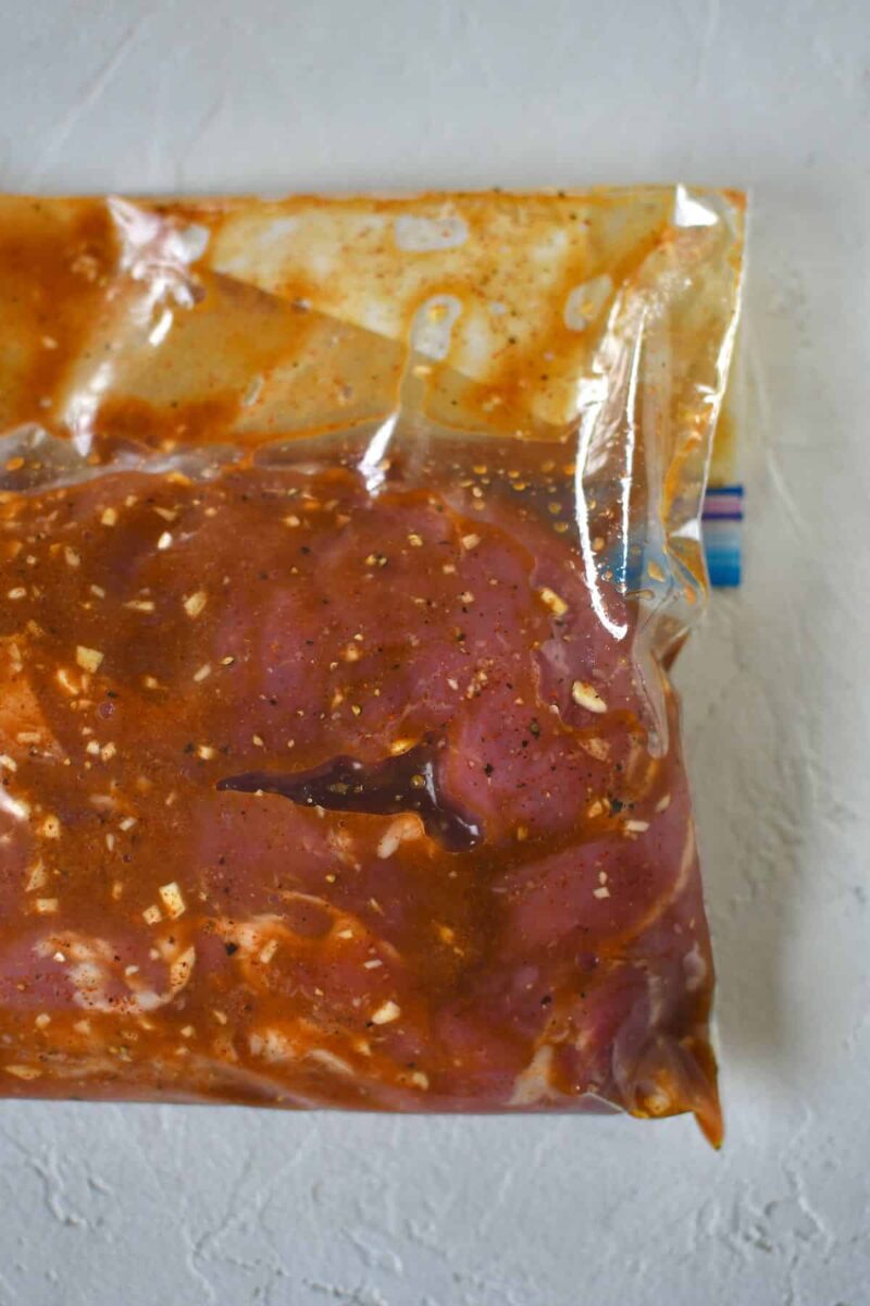 Pork tenderloins marinating in a zip top bag.