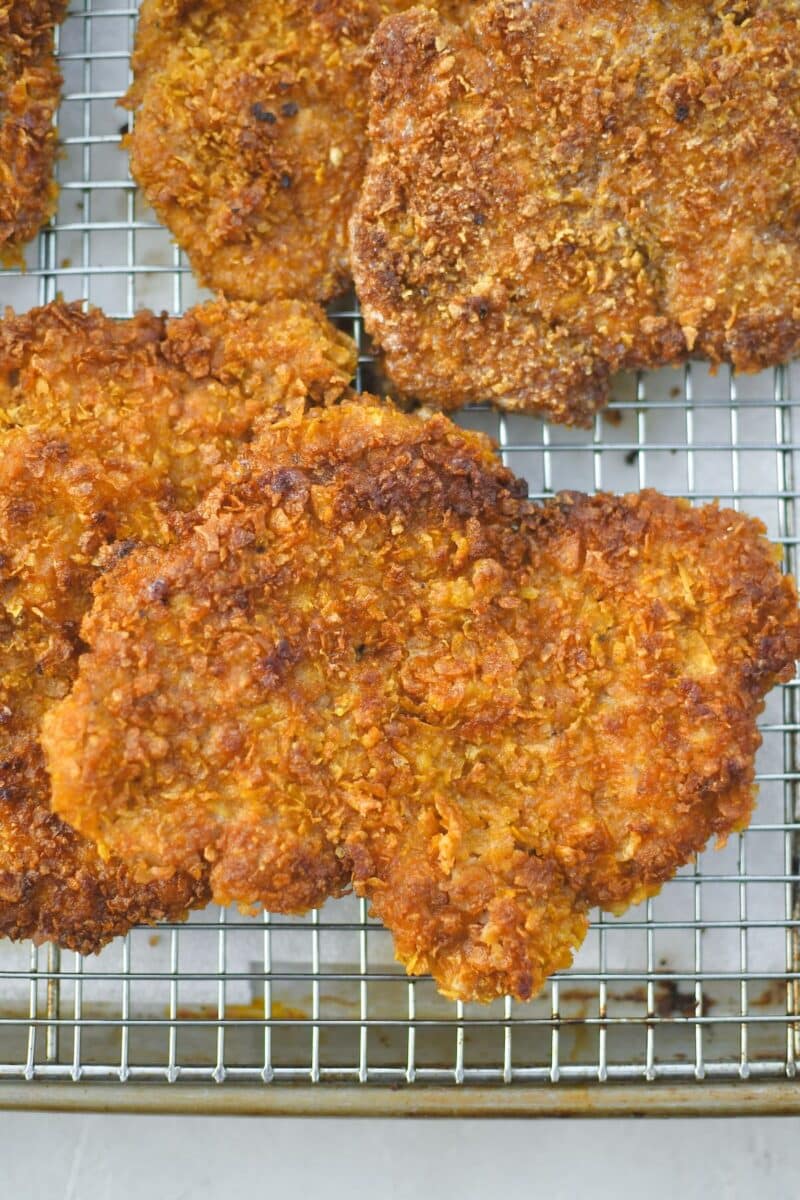 Schnitzel just out of the frying pan rest on a wire rack so they stay crispy.