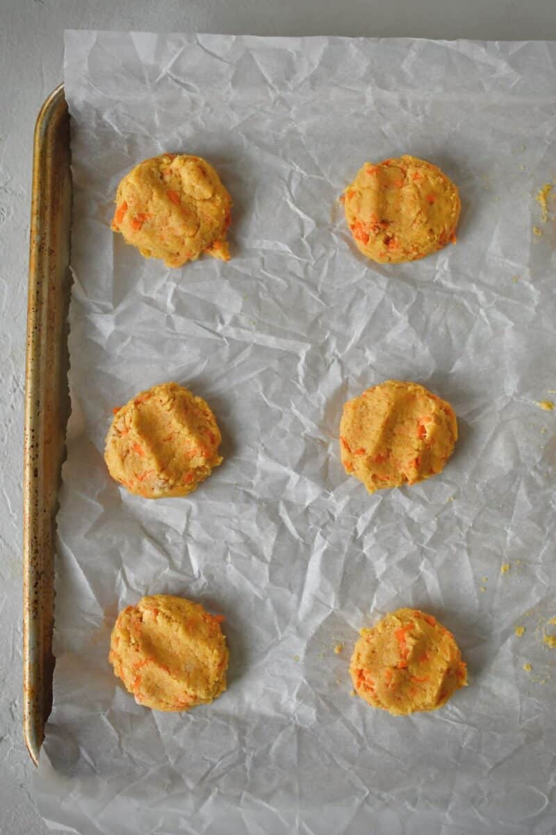 Portioning out the cookies on a parchment lined sheet pan.