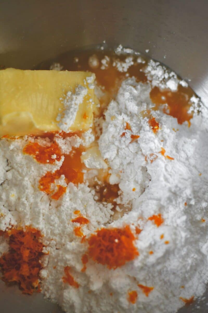 Making the frosting, butter, powdered sugar, orange juice and zest in a mixer bowl.