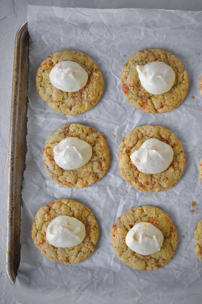 Adding dollops of frosting to the cookies before spreading it out.