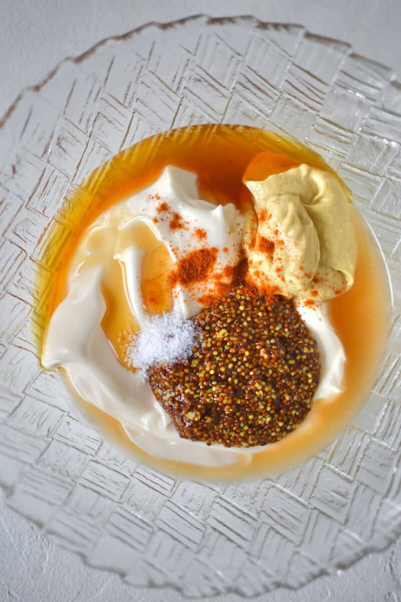 All ingredients for the honey mustard dressing added to a bowl, before mixing.