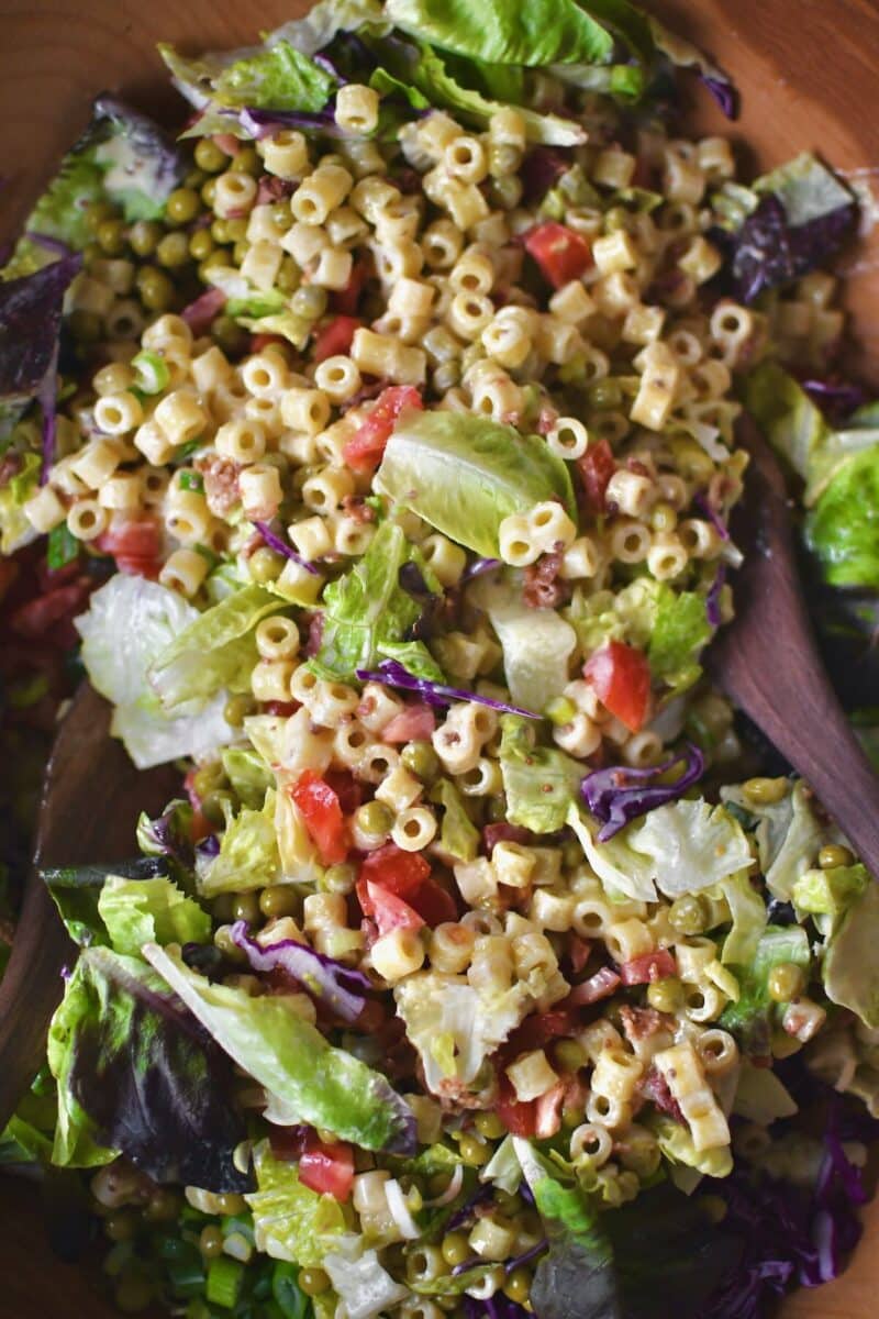 Tossing the salad together with all the toppings.