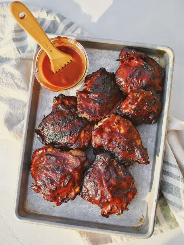 Grilled Chicken Thighs fresh off the grill and slathered in bbq sauce.