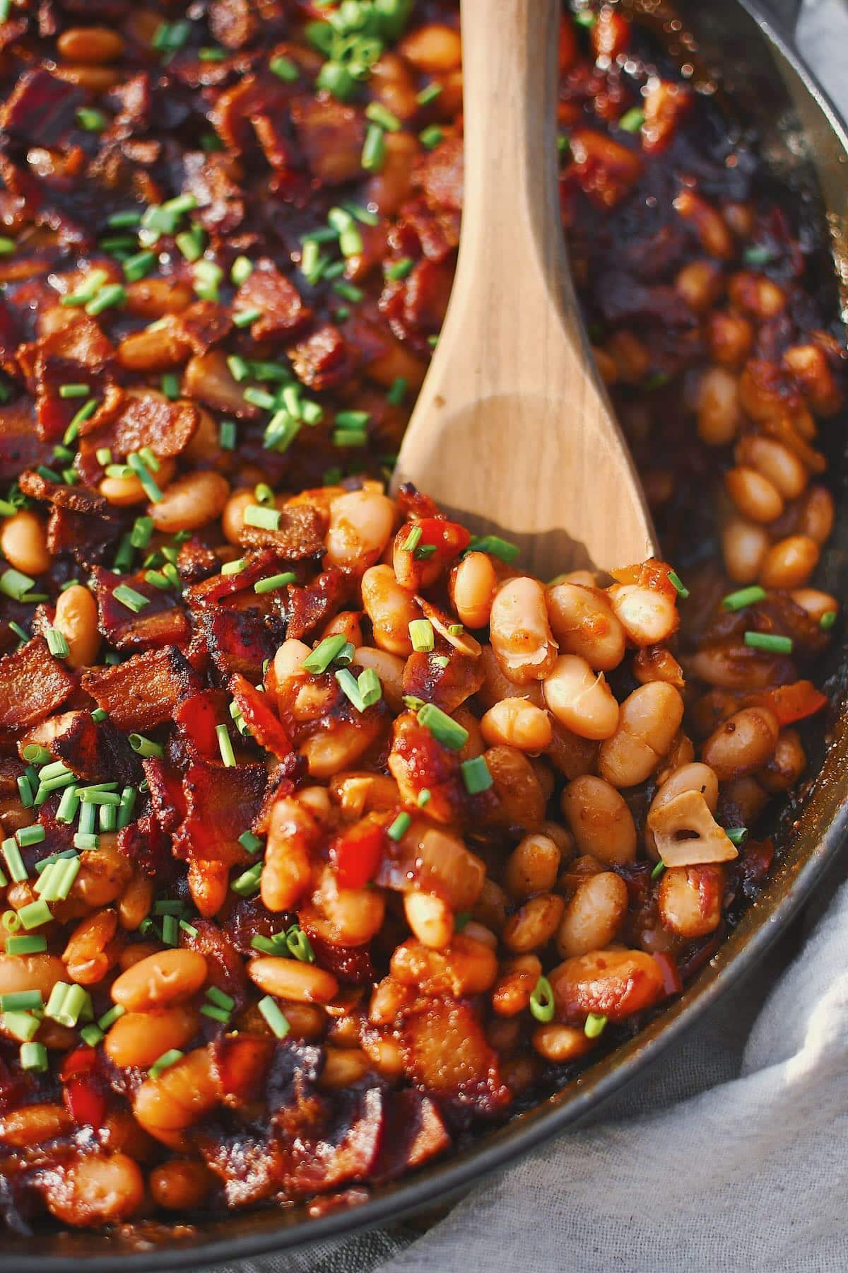 Dr. Pepper Baked Beans, just out of the oven and topped with chives. Spooning some out to eat.