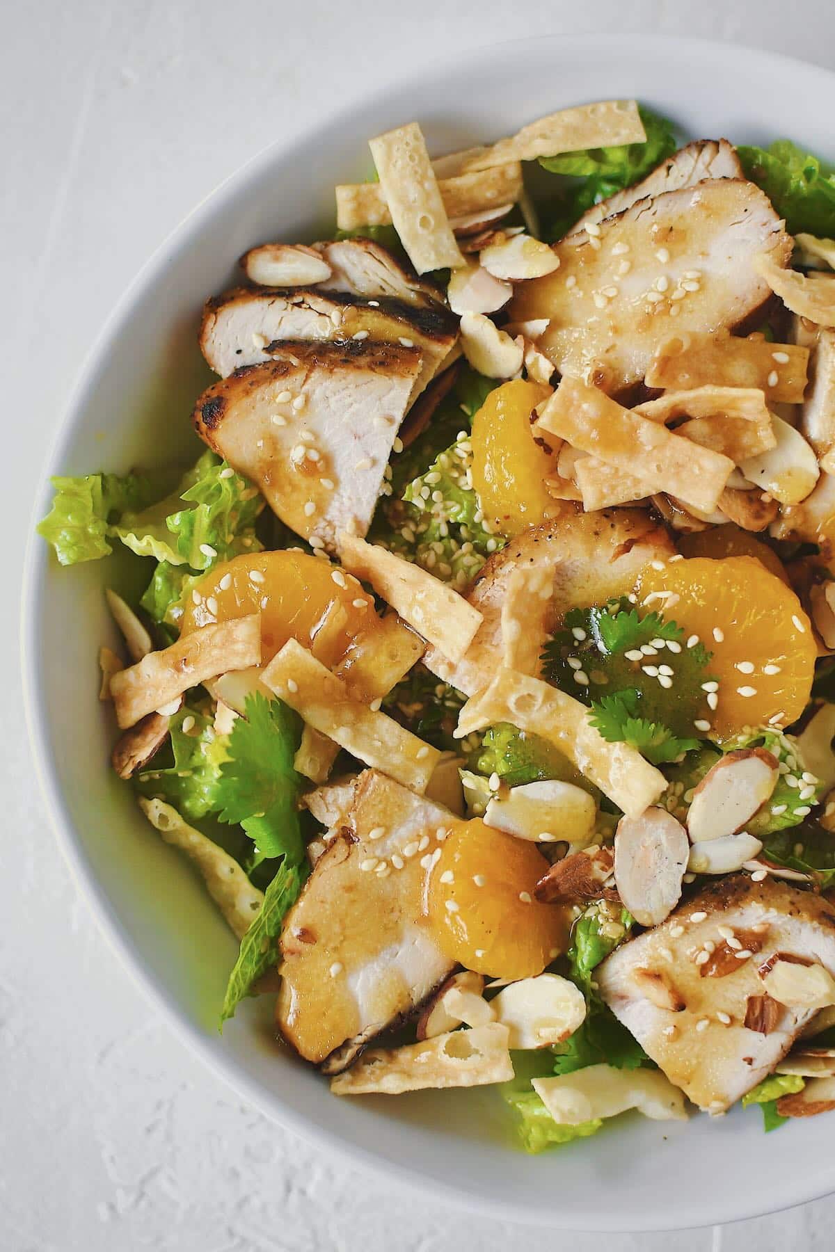 Chicken, crispy wontons, and sliced almonds added to the salad.