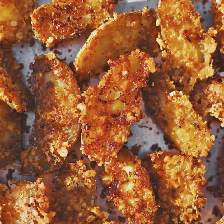 Potatoes after baking, that have been flipped to reveal the crisped cheese stuck to the potatoes.