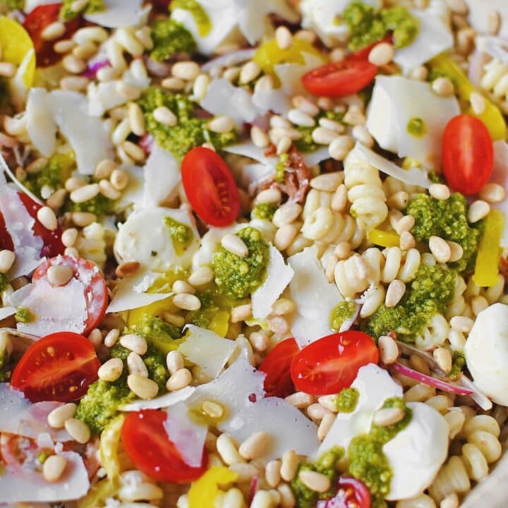 Fully dressed Pesto Pasta Salad topped with pesto and freshly shaved parmesan before serving.
