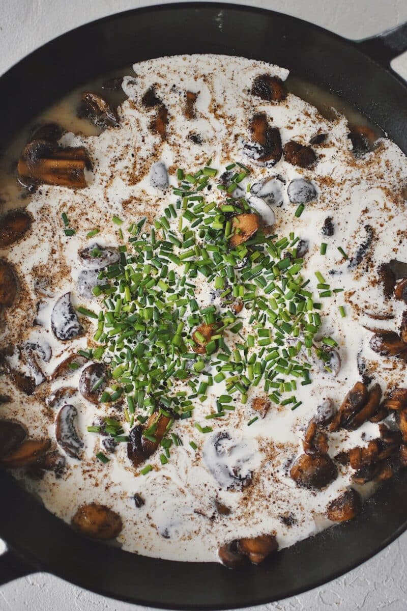 Adding the stock and cream to the pan to create a sauce.