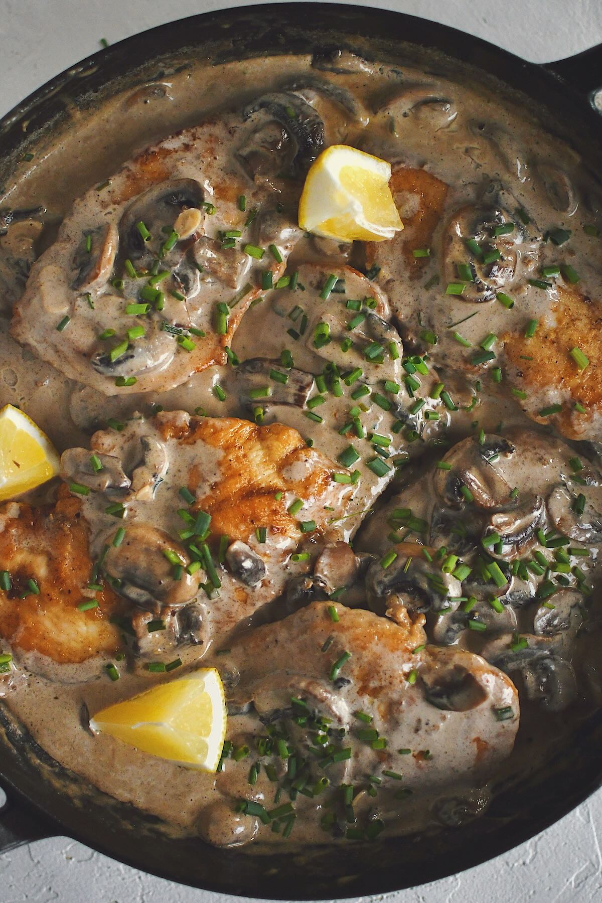 Creamy Mushroom Chicken, finished in the pan and topped with chives and a squeeze of lemon.