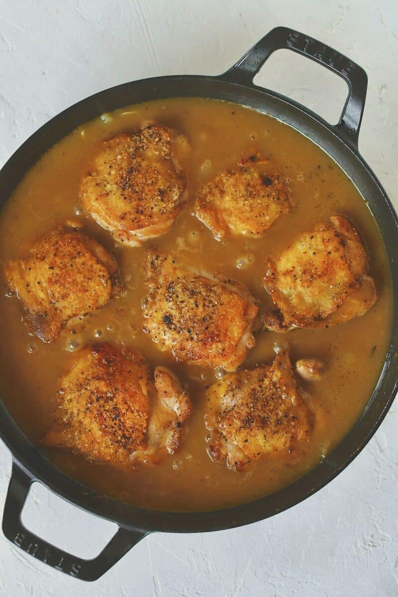 Adding the chicken back to the pan after simmering the sauce.