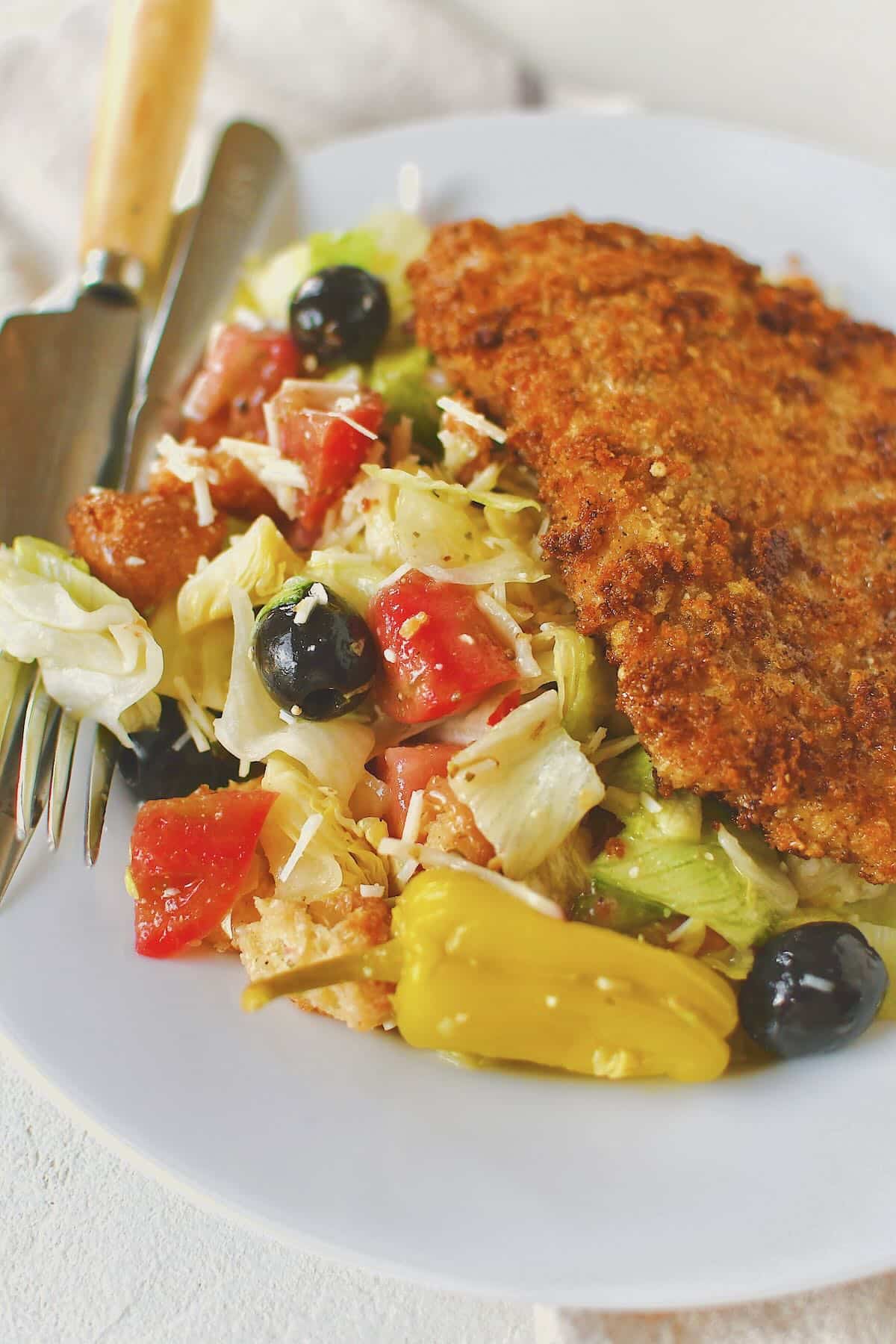 Italian Salad served with a parmesan chicken cutlet.