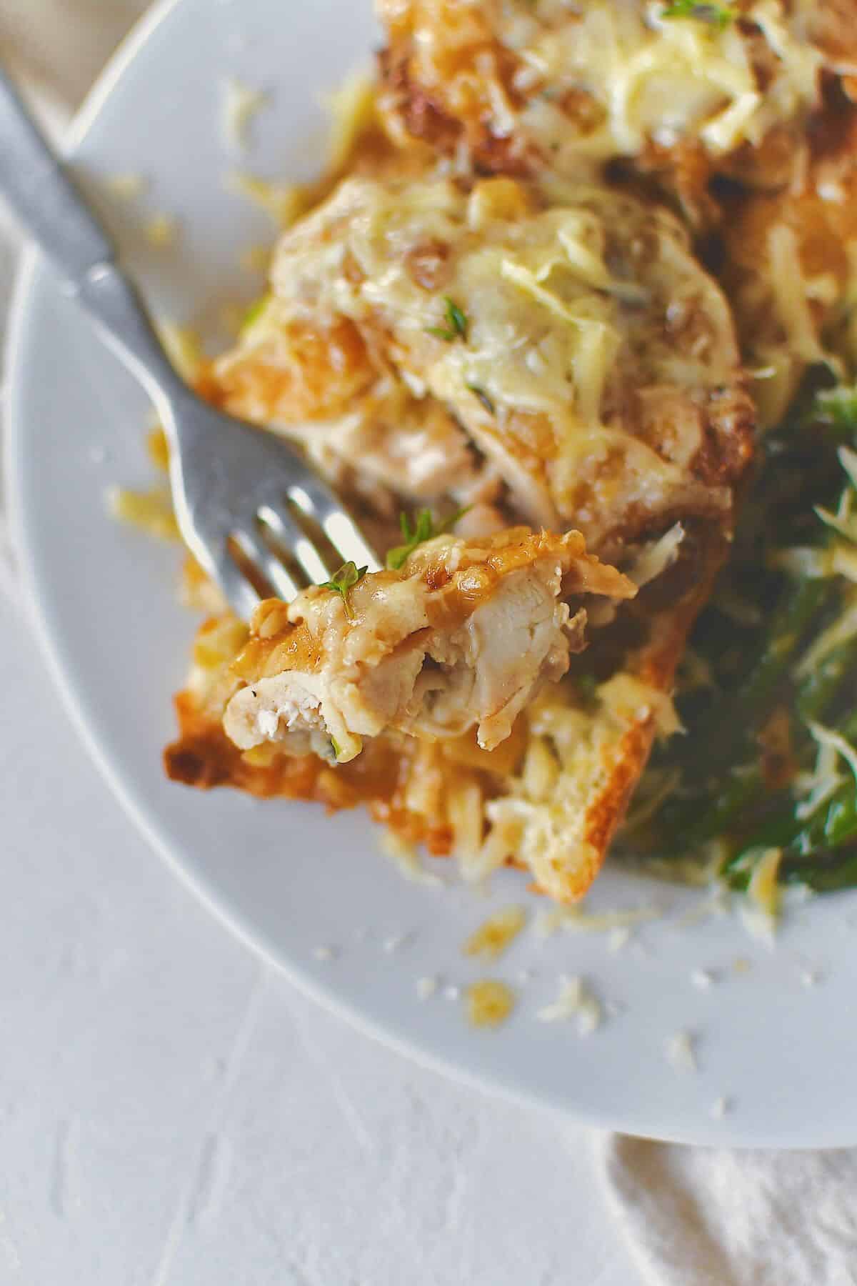 French Onion Chicken served over a piece of crusty bread to soak up the extra sauce and some sauteed green beans.