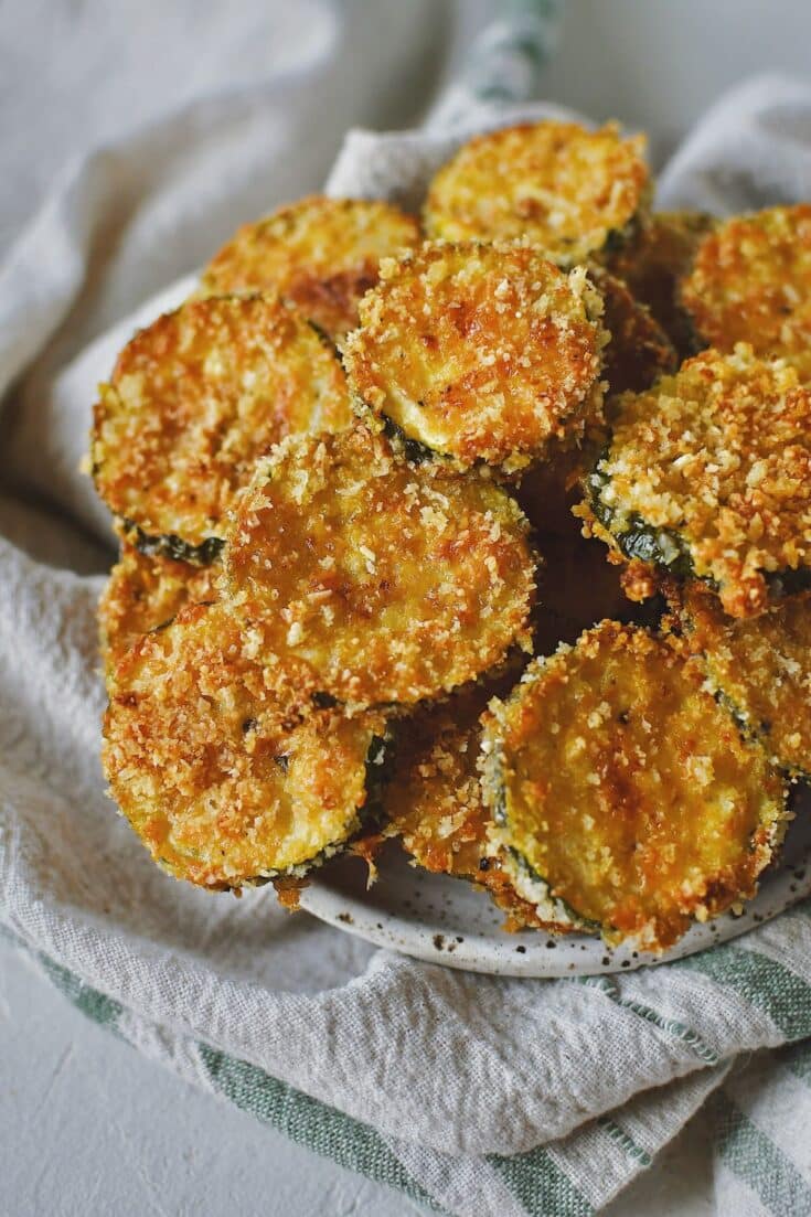 Zucchini Chips after baking, stacked on a plate and ready to eat.