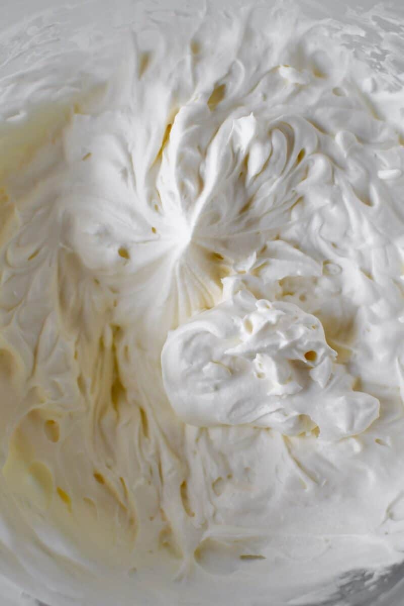 Freshly whipped cream in a stand mixer bowl.