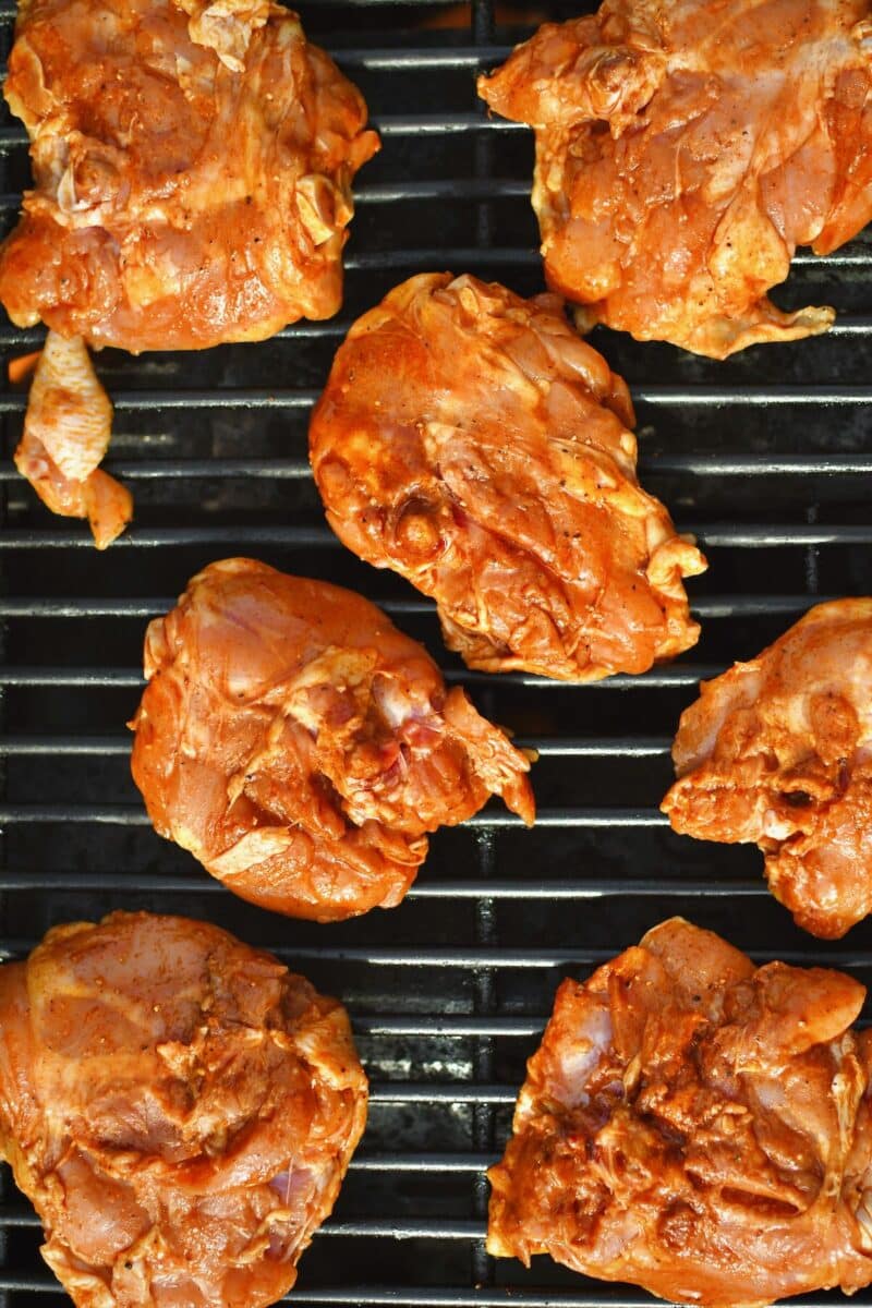 Seasoned chicken placed on the hot grill, skin side down to crisp the skin.