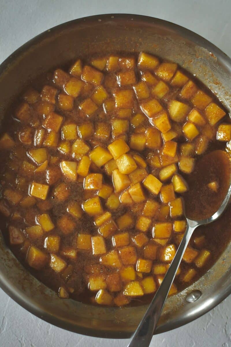 Diced fresh apples, caramel, and cinnamon in a skillet, after cooking.