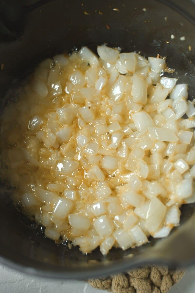 Sauteing the onions and garlic in butter in a saucepan.