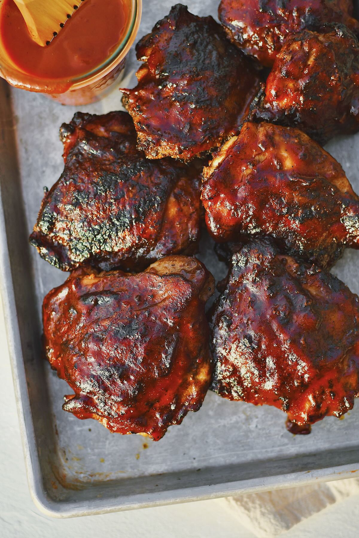 Grilled Chicken Thighs fresh off the grill and slathered in bbq sauce.