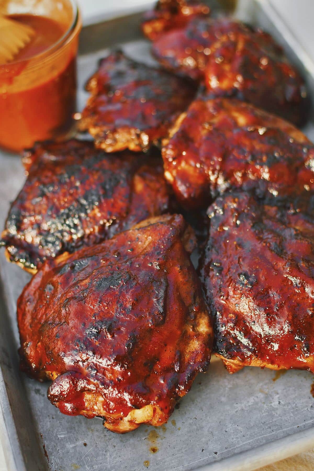 Grilled Chicken Thighs fresh off the grill and slathered in bbq sauce.