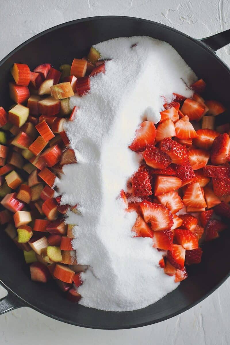 Rhubarb, strawberries and sugar added to the cooking pan.