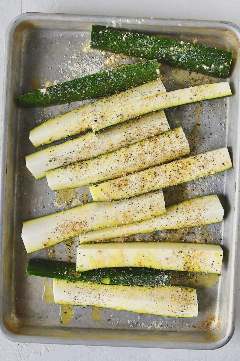 Cut zucchini on a sheet pan, with the oil and seasonings drizzled over.