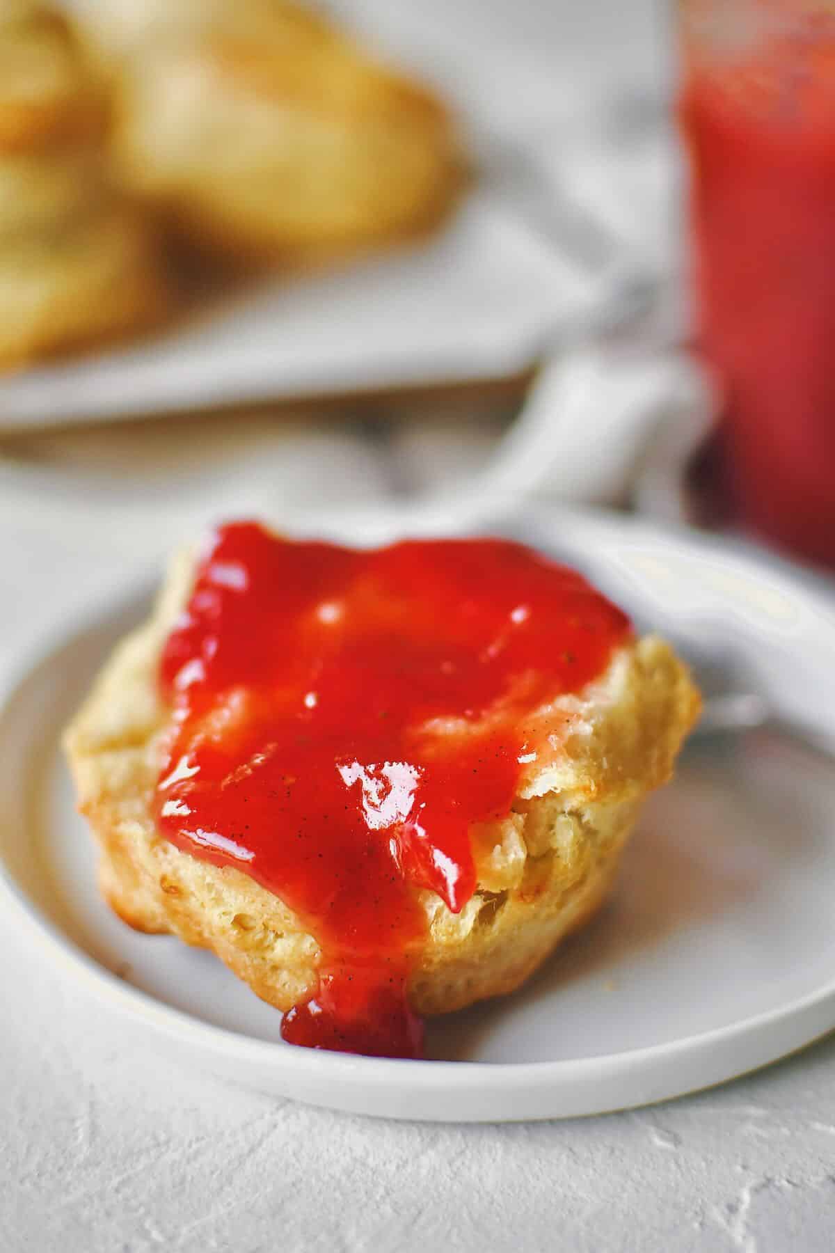 Strawberry Rhubarb Jam being enjoyed on a fresh biscuit.