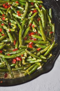 Creamed Green Beans ready to eat and topped with some diced tomatoes.