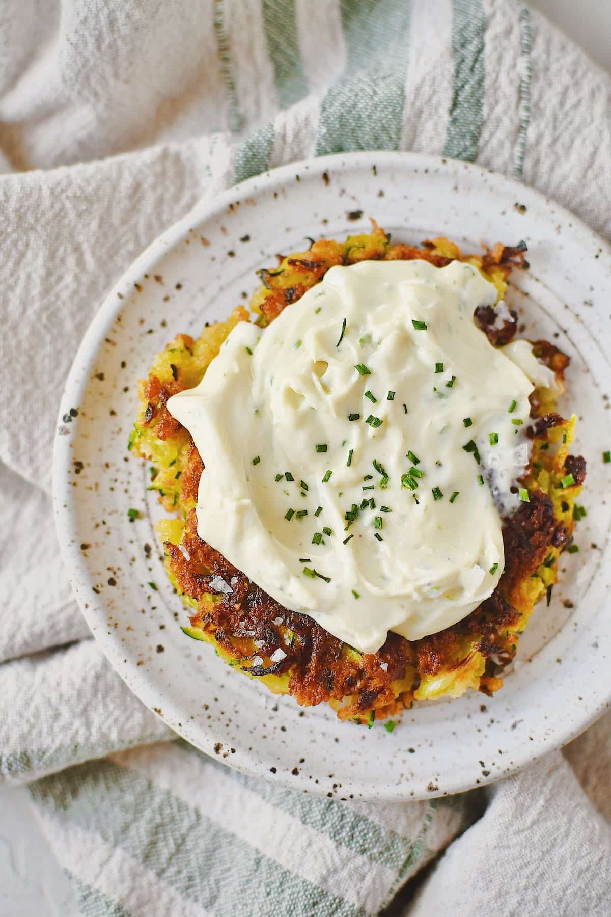 Zucchini Fritter topped with whipped goat cheese and ready to enjoy.