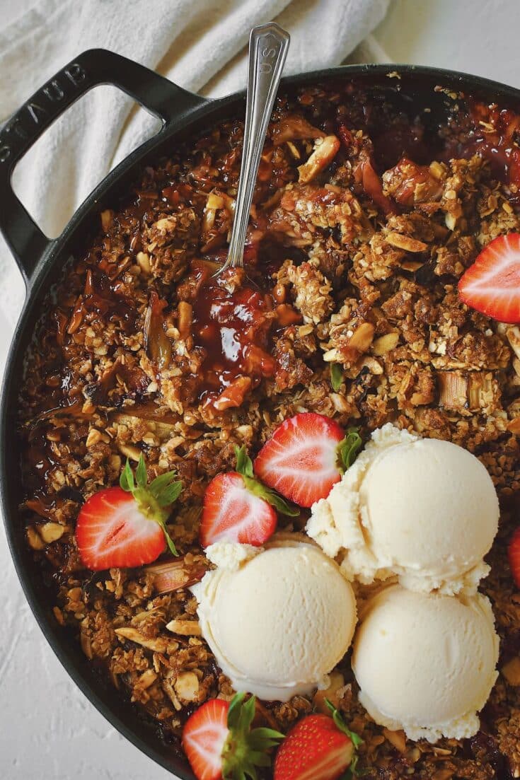 Strawberry Rhubarb Crisp, fresh from the oven and topped with fresh ice cream and sliced strawberries.