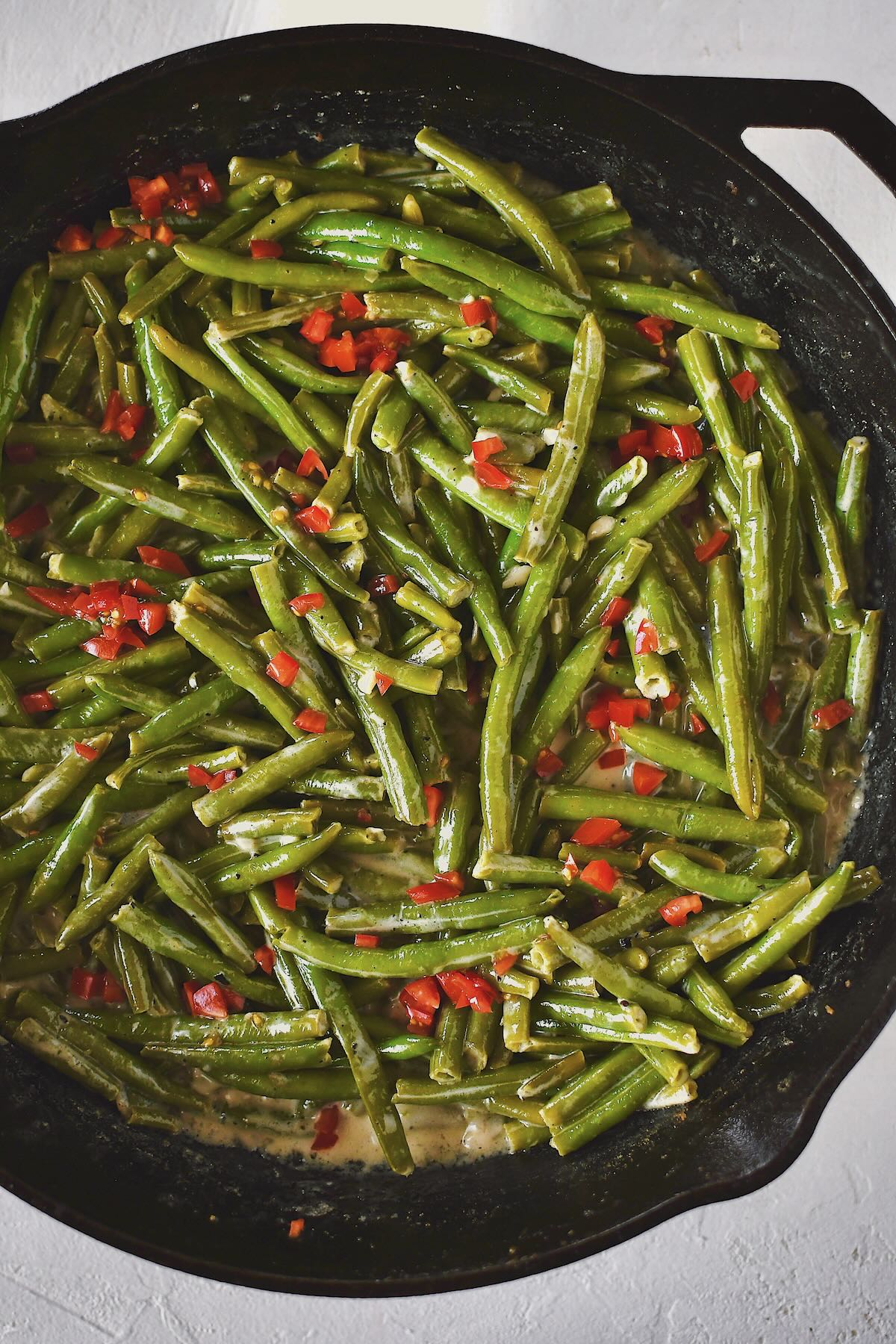 Creamed Green Beans ready to eat and topped with some diced tomatoes.