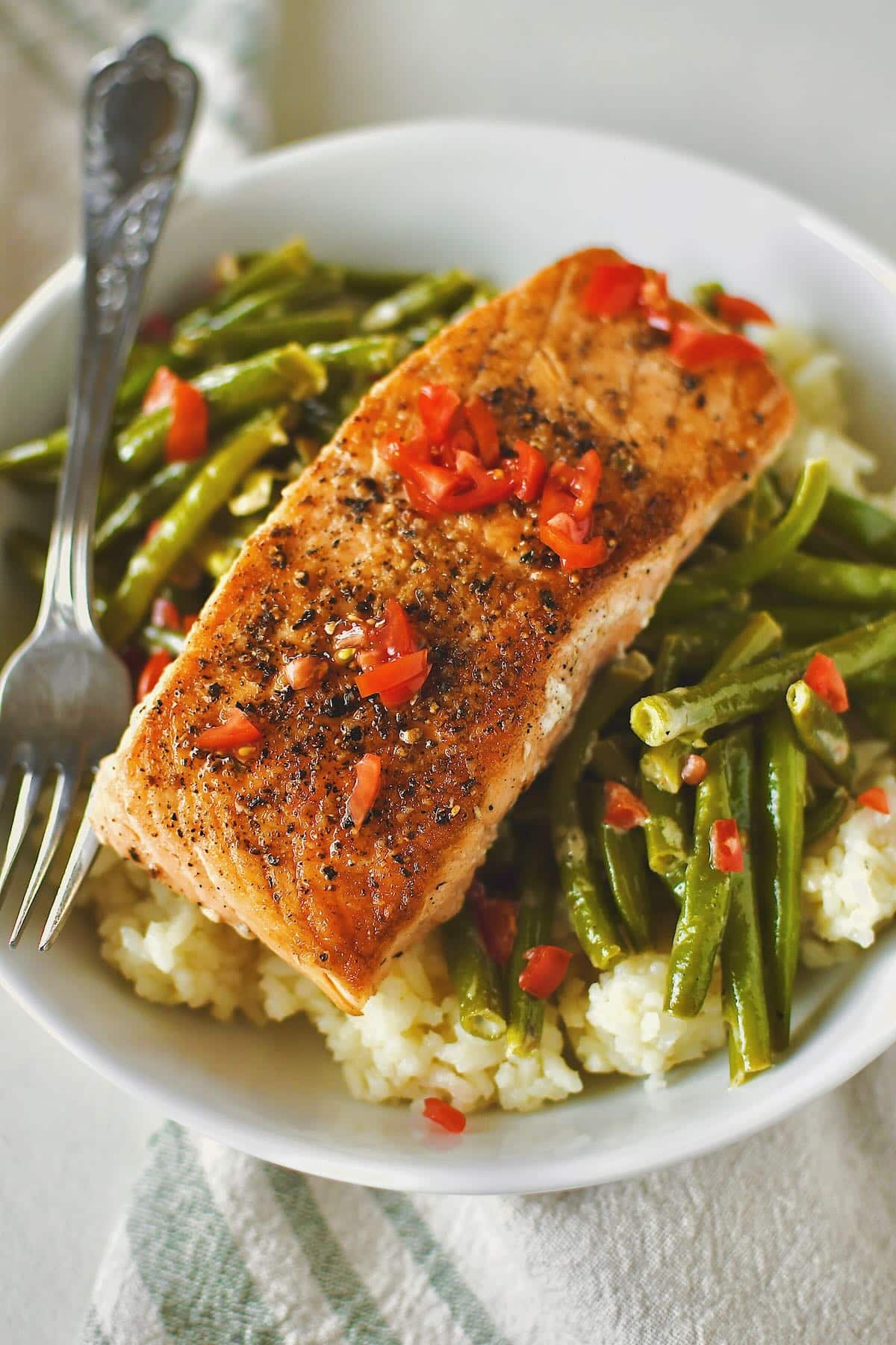 Creamed Green Beans served over some rice and topped with seared salmon.