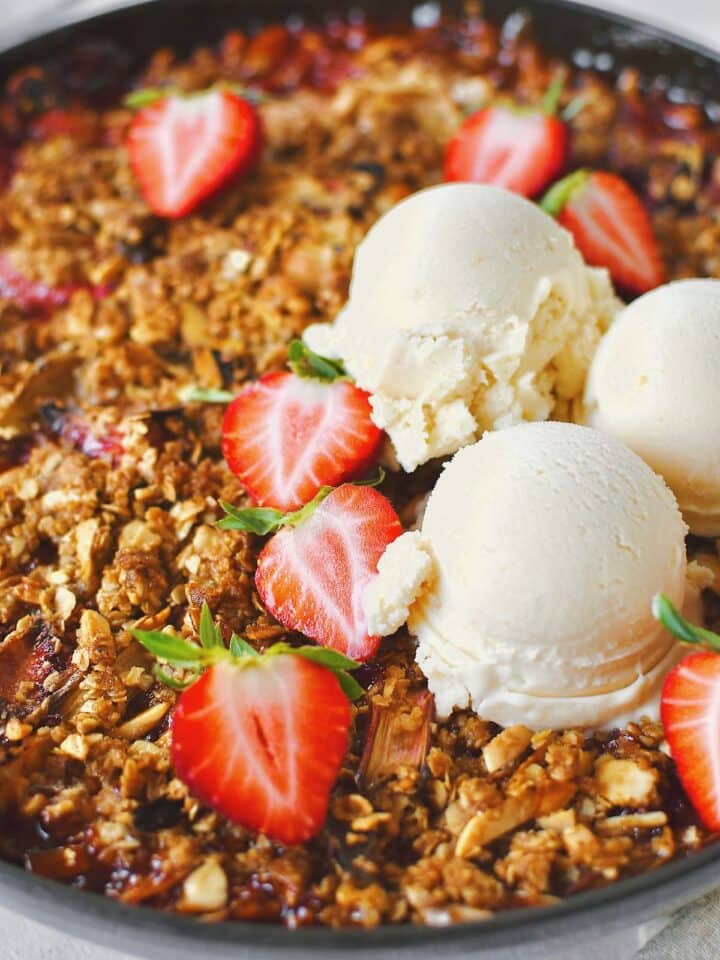 Strawberry Rhubarb Crisp, fresh from the oven and topped with fresh ice cream and sliced strawberries.