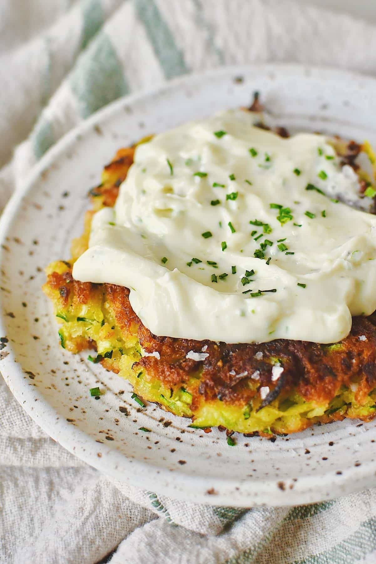 Zucchini Fritter topped with whipped goat cheese and ready to enjoy.