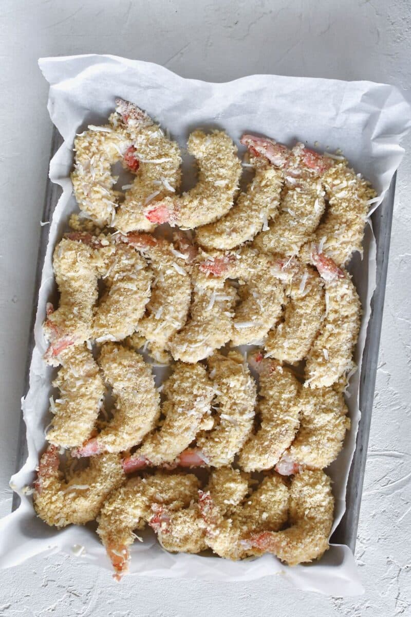 Shrimp, lined up on a sheet pan after breading them.