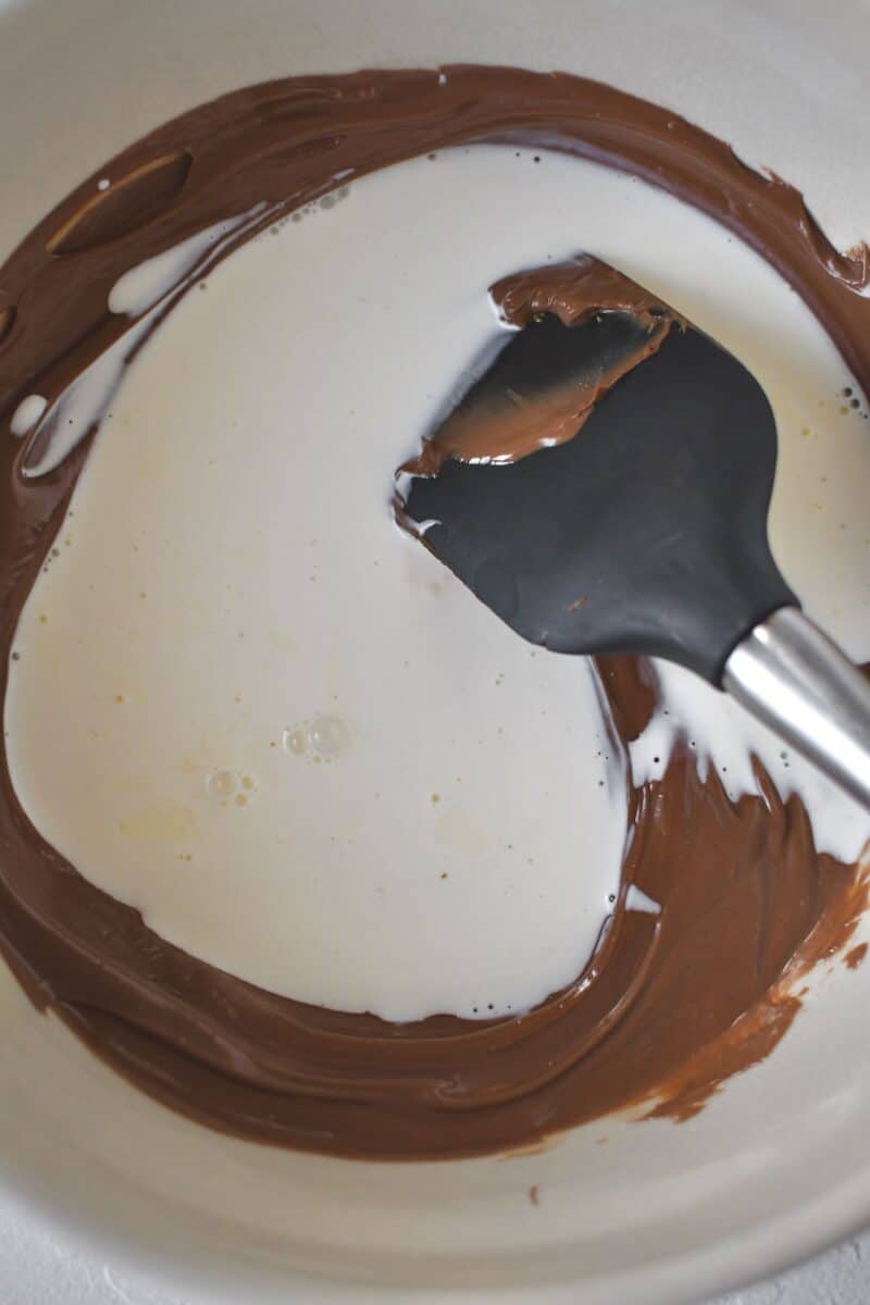 Stirring together the warmed cream and nutella to make the ganache.
