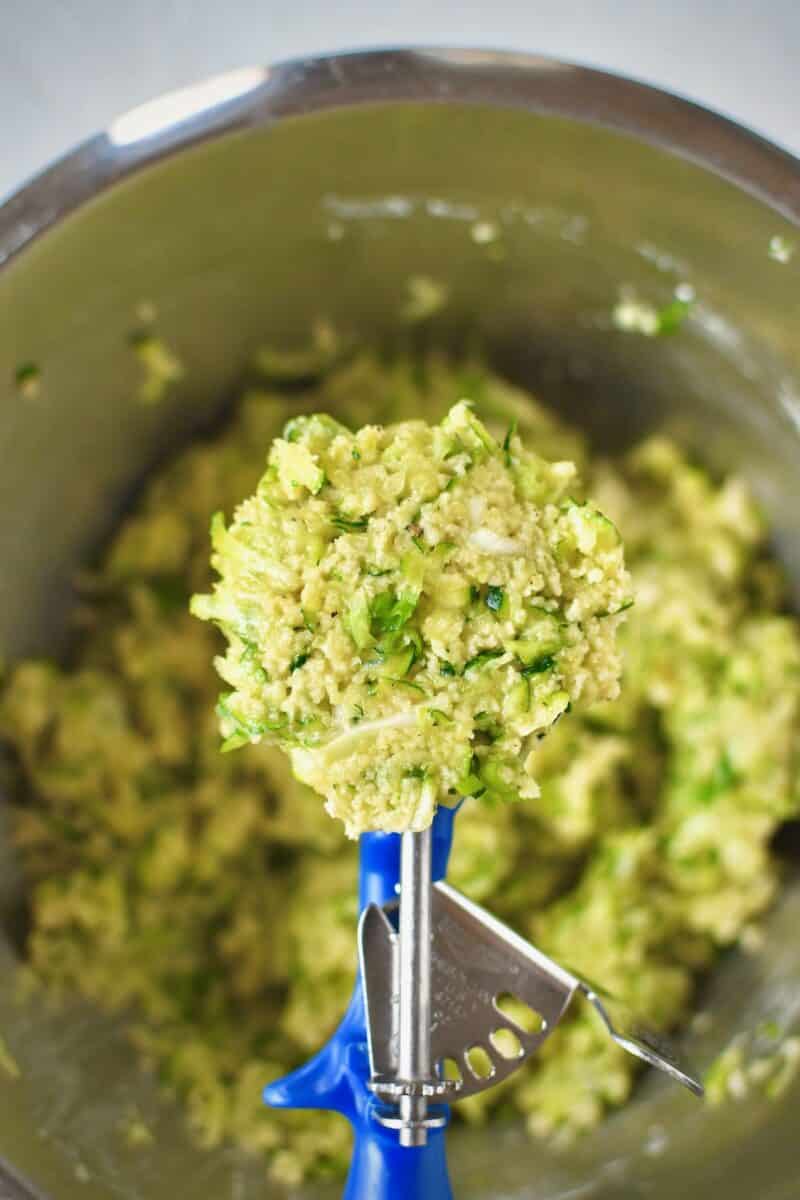 Scooping portions of the zucchini batter.