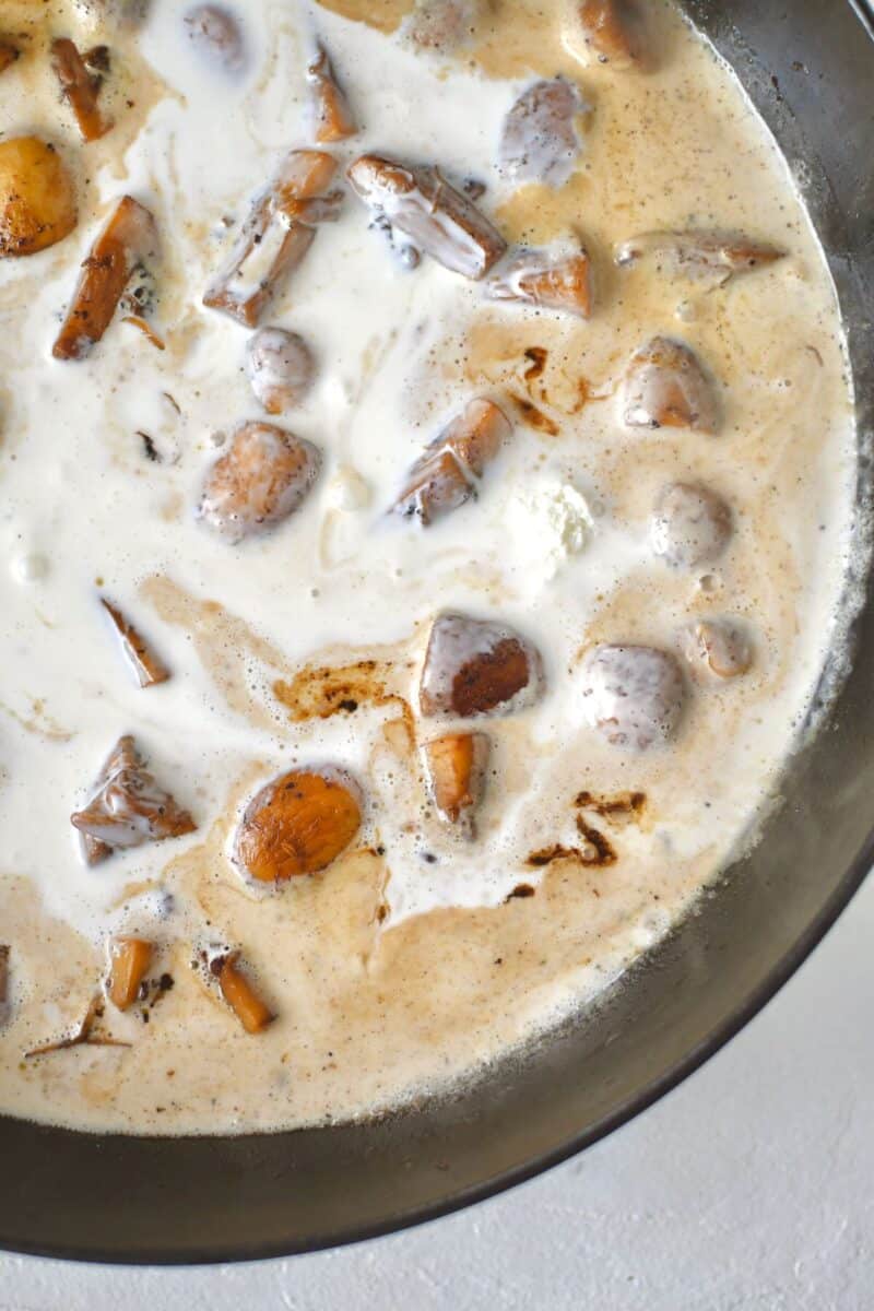 White Wine cream sauce simmering in a large skillet with the mushrooms and garlic.