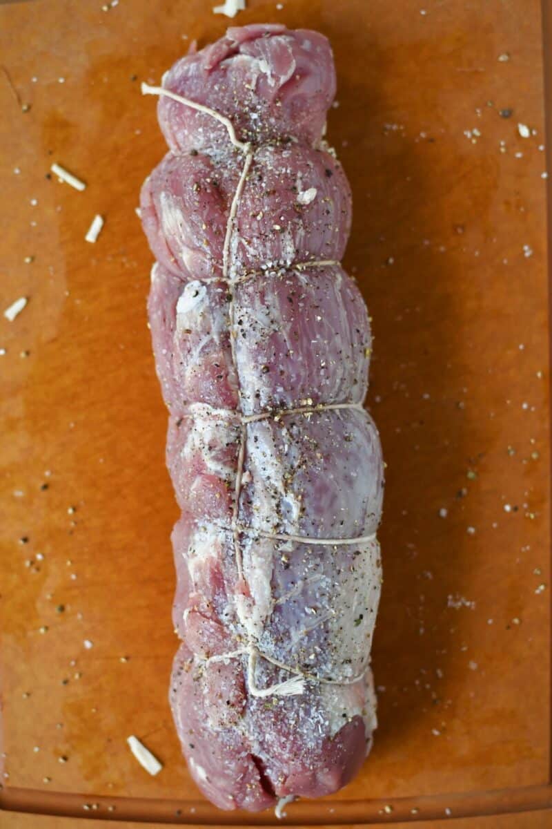 A pork tenderloin that has been stuffed and rolled up and trussed with twine.