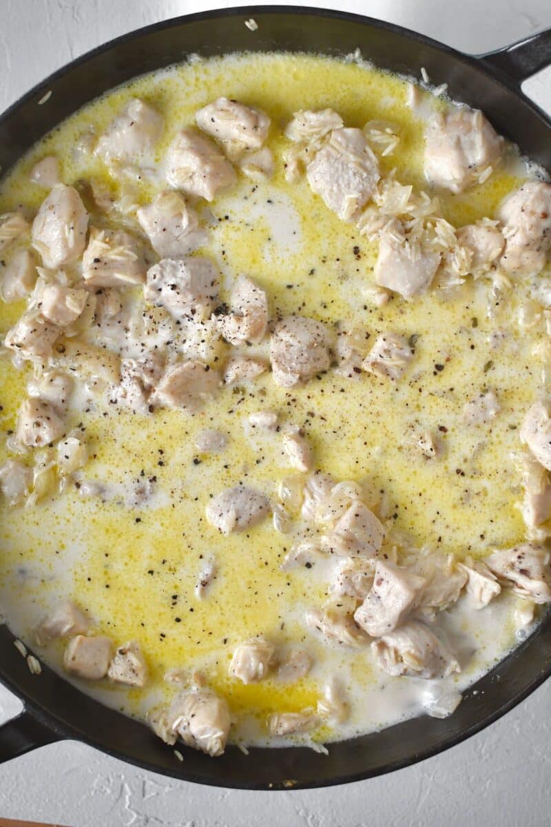 Cream, milk, and seasonings added to the pan to form a sauce.