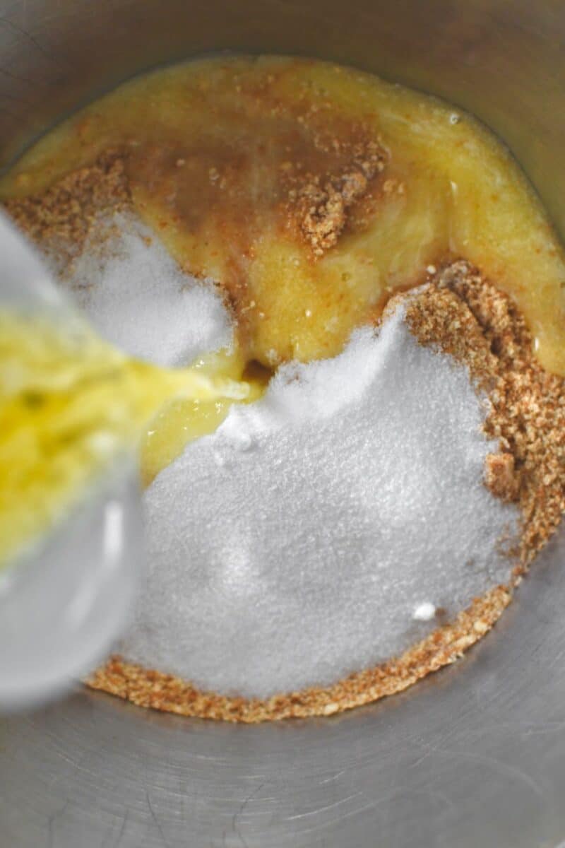 Combining nilla wafer crumbs, sugar, nutmeg, and melted butter to make the pie crust.