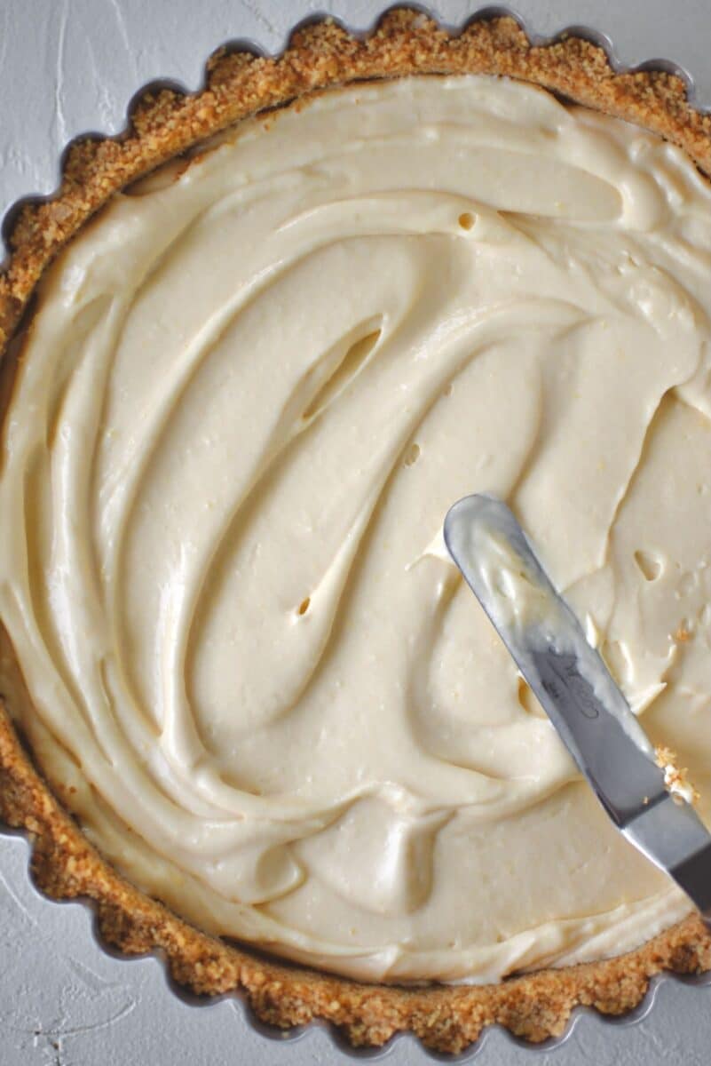 Adding half the filling to the cooled pie crust.