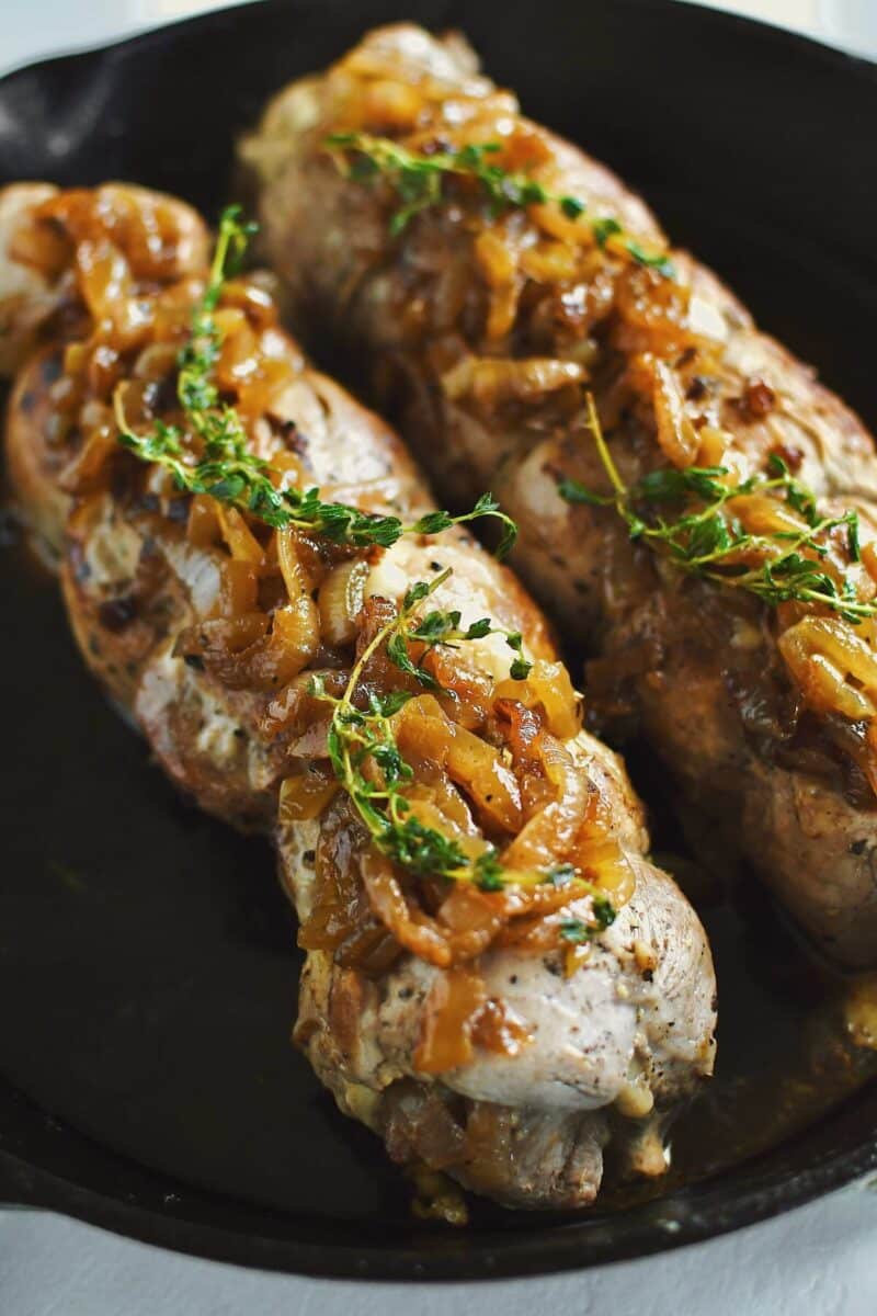 Stuffed Pork Tenderloins after searing and resting topped with extra onions and they thyme.