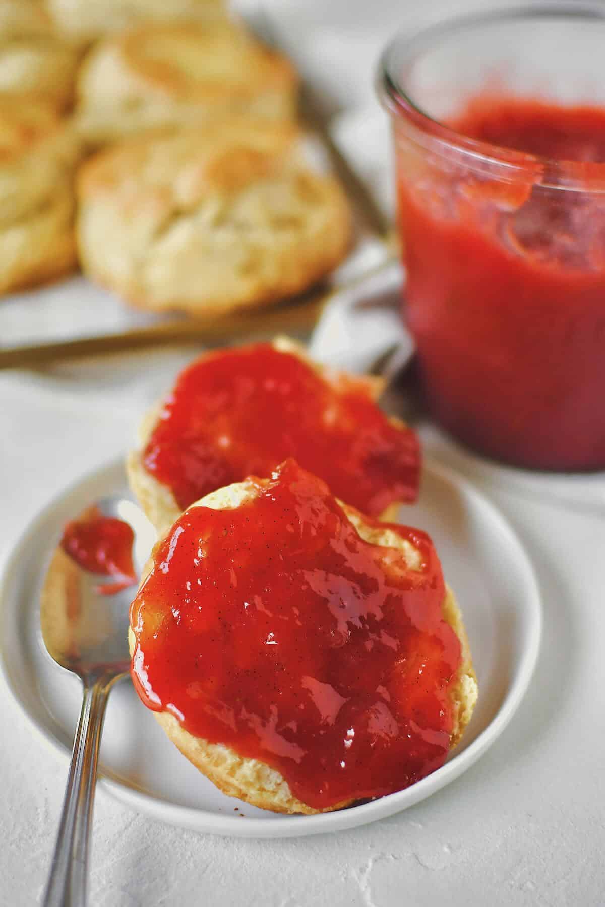 Strawberry Rhubarb Jam being enjoyed on a fresh biscuit.