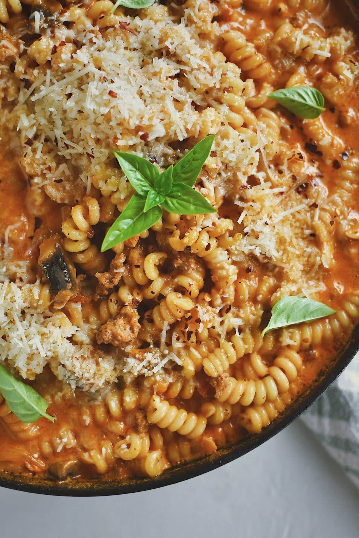 Italian Sausage Pasta finished in the pan and topped with extra parmesan and basil.